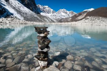 Harmony and balance: Stone stack and Sacred Lake near Gokyo. Travel to Nepal