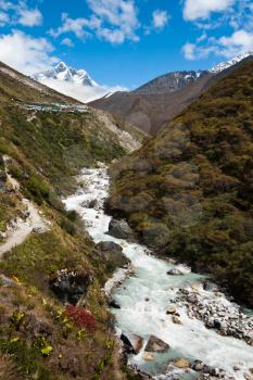 Himalaya landscape: peak, river and highland village. Pictured in Nepal