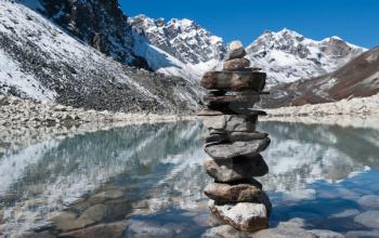 stability: Stone stack and Sacred Lake near Gokyo in Himalayas