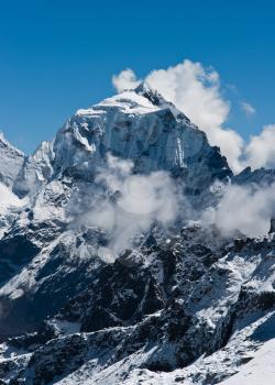 Taboche mountain peak and clouds viewed from Renjo pass. In Himalayas