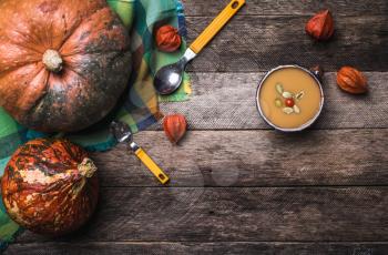 Rustic style pumpkins and soup with seeds and ground cherry on wood. Autumn Season food photo