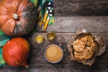 Rustic style pumpkins, soup, honey and cookies with nuts on wood. Autumn Season food photo
