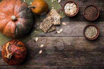 Rustic style pumpkins with seeds and cookies on wooden table. Autumn Season food photo