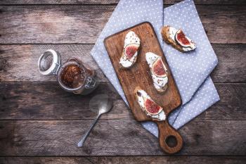 Bruschetta and Sliced figs on chopping board in rustic style. Breakfast, lunch food photo