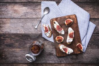 Bruschetta, jam and Sliced figs on chopping board in rustic style. Breakfast, lunch food photo