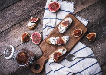 Bruschetta snacks with cut figs on napkin in rustic style. Breakfast, lunch food photo