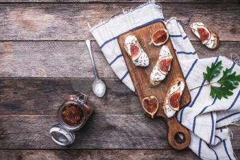 Bruschetta with figs on chopping board in rustic style. Breakfast, lunch food photo