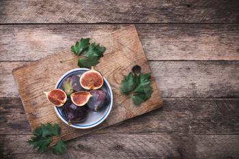 rustic style Cut figs in flat dish on choppingboard. Autumn season food photo