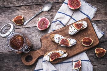 Bruschetta snacks with jam and figs on napkin in rustic style. Breakfast, lunch food photo