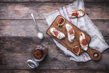 rustic style Bruschetta with jam and Sliced figs on chopping board. Breakfast, lunch food photo