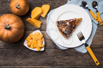 Tasty pie on plate and pieces of pumpkin in Rustic style. Food photo