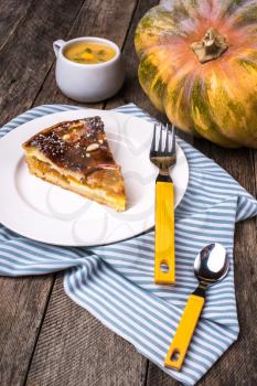piece of Pumpkin pie with mousse on wood in Rustic style