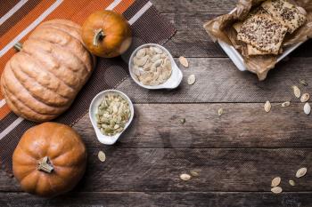 Rustic pumpkins with cookies and seeds on wood. Autumn Season food photo