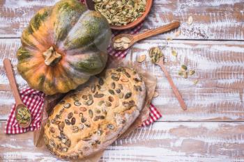 Rustic style baked bread with seeds and pumpkin on wood. Food Photo
