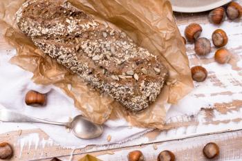 Bread with seeds huzelnuts on wooden board in rustic style