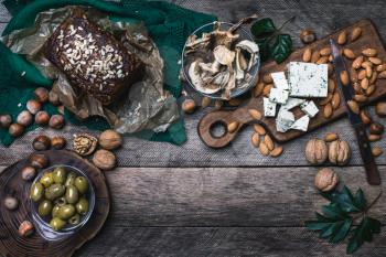 Rustic style olives, nuts mushrooms  and bread  with seeds on wood
