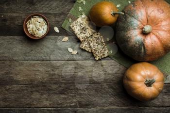 Rustic style pumpkins and cookies with seeds on wooden table. Autumn Season food photo
