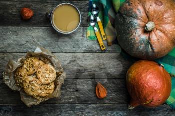 Rustic style pumpkins soup and cookies with seeds on wood. Autumn Season food photo