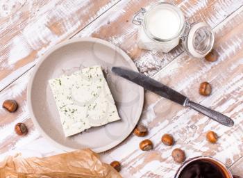 cheese with dill and joghurt for breakfast on wooden table in rustic style
