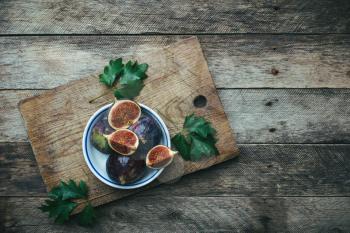 Ripe Figs on board in rustic style. Autumn season food photo