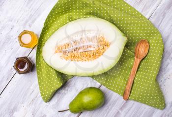 tasty melon with honey and pears on wood in rustic style