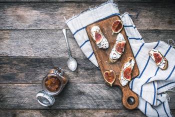 Healthy snacks with cheese and figs on wood board and napkin. Breakfast, lunch food photo