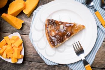 Piece of pie and Pumpkin slices in Rustic style. Food photo