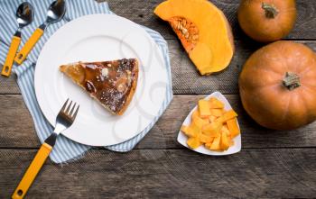 Piece of pie and Pumpkin slices on wood in Rustic style