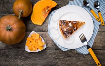 Piece of pie and Pumpkin slices on wooden tablein Rustic style