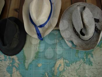 Royalty Free Photo of Old Hats Hanging in Front of a Map