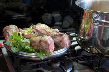 Royalty Free Photo of Raw Lamb Shanks With Parsley on a Stove