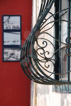 Royalty Free Photo of a Wrought Iron Window in Front of a Red Wall