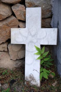Royalty Free Photo of a Cross Leaning Against Rocks