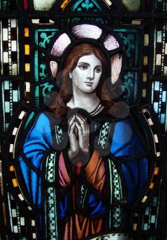 Royalty Free Photo of a Stained Glass Window With a Woman Praying