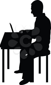 A silhouette of a man sitting at a laptop computer