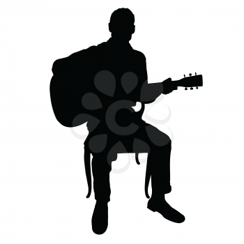 Silhouette of a man playing an acoustic guitar