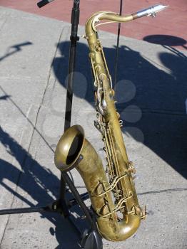 Old saxophone rested on the stand during the street musicians performance.
