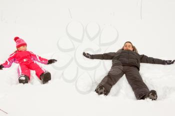 Brother and sister playing Snow Angels.
