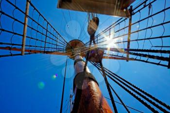 View of mast and rigging on the sail ship against the deep blue summer sky.