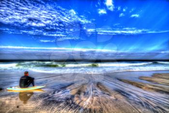 Sandy beach with a surfer.