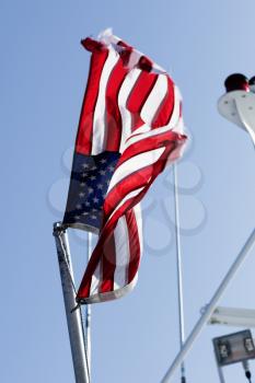 Weathered American flag on a flag pole.