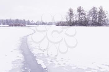 Beautiful view of the frozen forest lake in the winter.