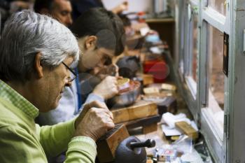 Toledo, Spain- November 04, 2015: Artisan jewelers creating hand made jewelry items in a workshop.