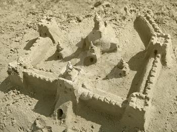 a big sandcastle with towers on the beach
