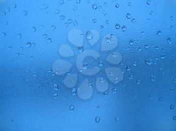 Large and fine water drops on glass