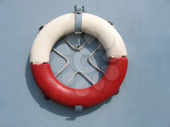 red and white lifebuoy ring hanging on a wall