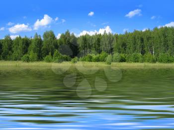 summer landscape with bright blue sky and trees reflected in water