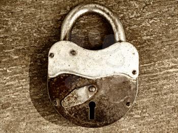 old rusty padlock on wooden background                               