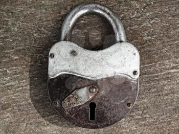 old rusty padlock on wooden background                               