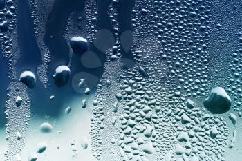 large and fine water drops on window glass